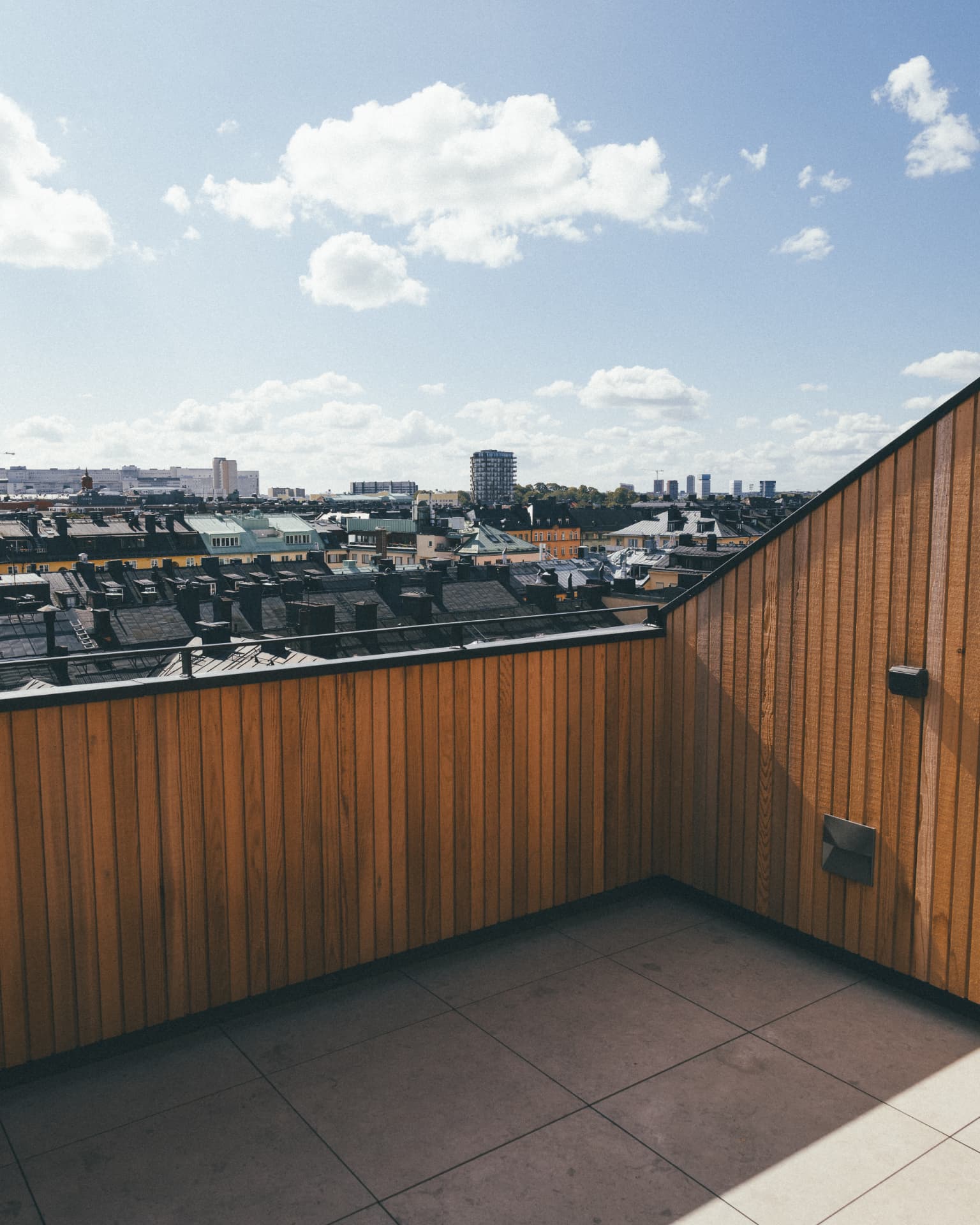 Renoverad piskbalkong med utsikt över stadens tak
